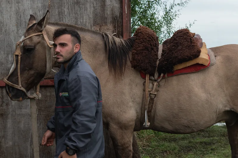 Retrato rural para web: gaucho junto a un caballo ensillado en la provincia de Buenos Aires